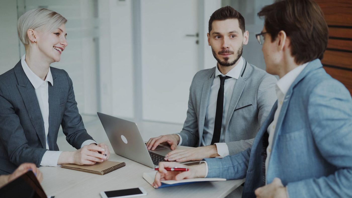 Colleagues in a meeting reviewing documents in a modern office