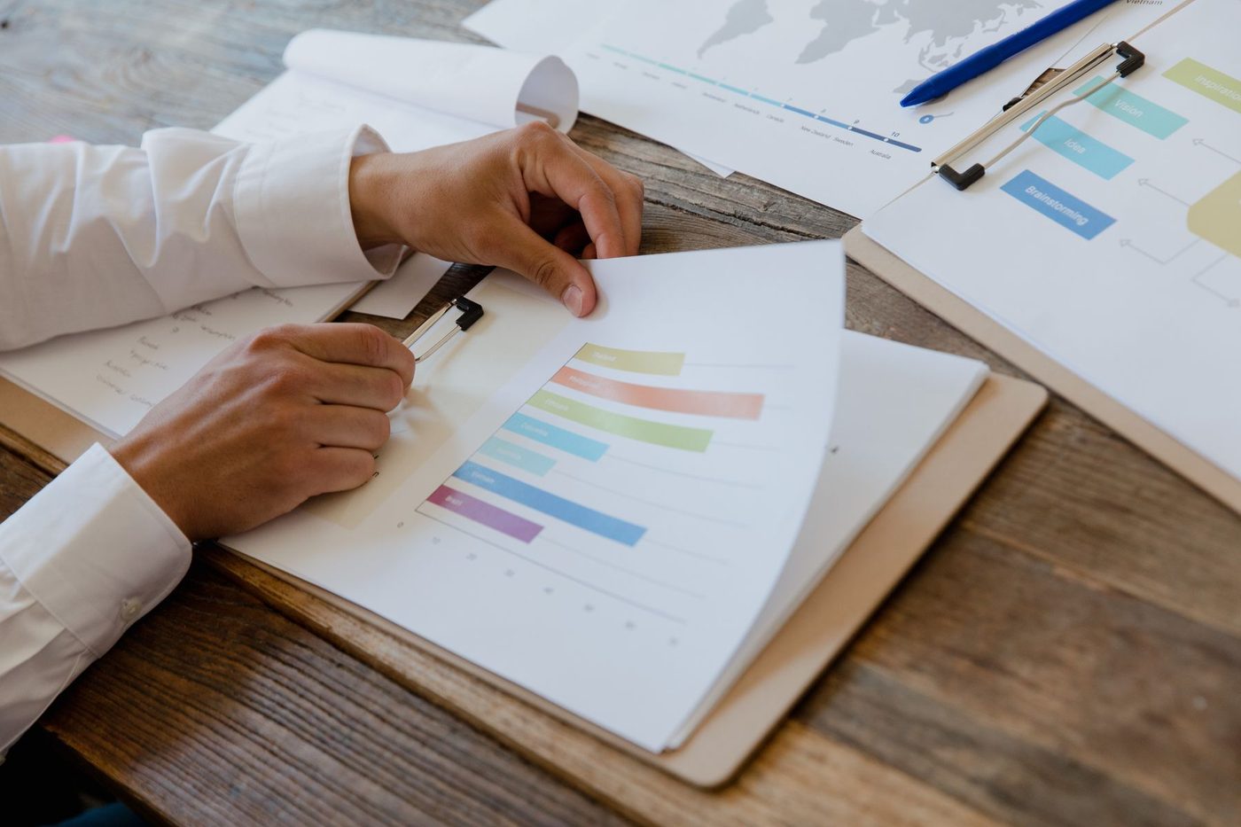 Hands reviewing a printed business report with charts